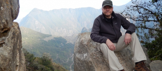 Photo of Rob Rutenbar sitting on a boulder overlooking a canyon